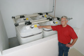 image004 Mann mit rotem Shirt steht vor Auffangwanne für Batterietank_Lexikon_Lutz Tankschutz Karlsruhe